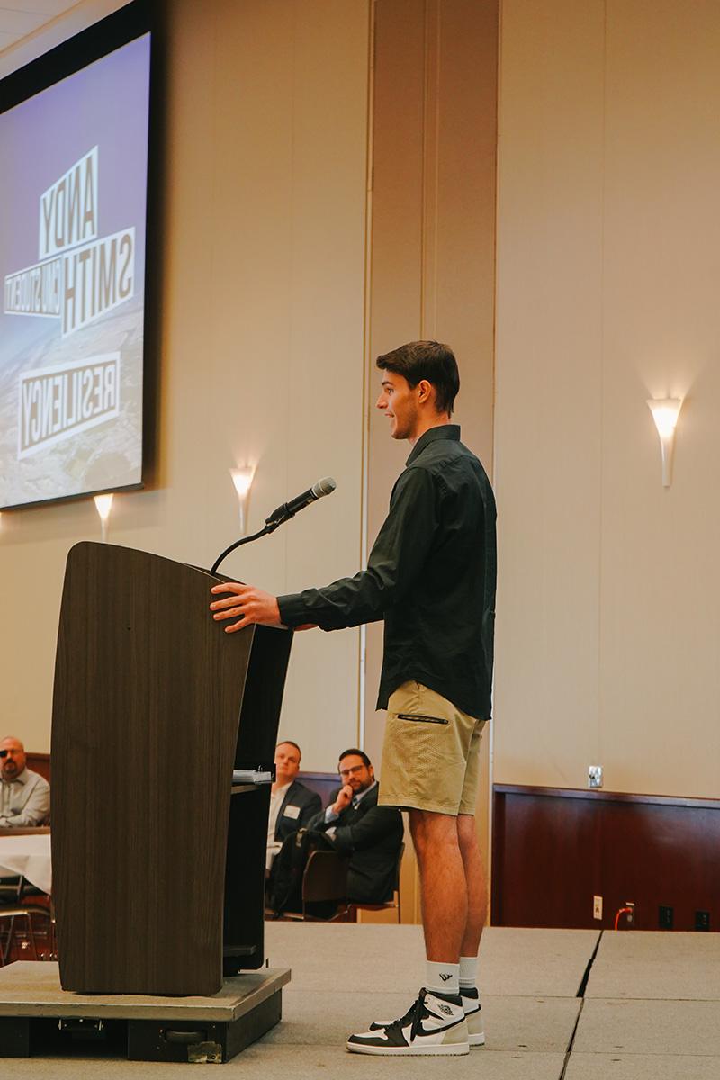 Student Andy Tyler on stage speaking at the kickoff event